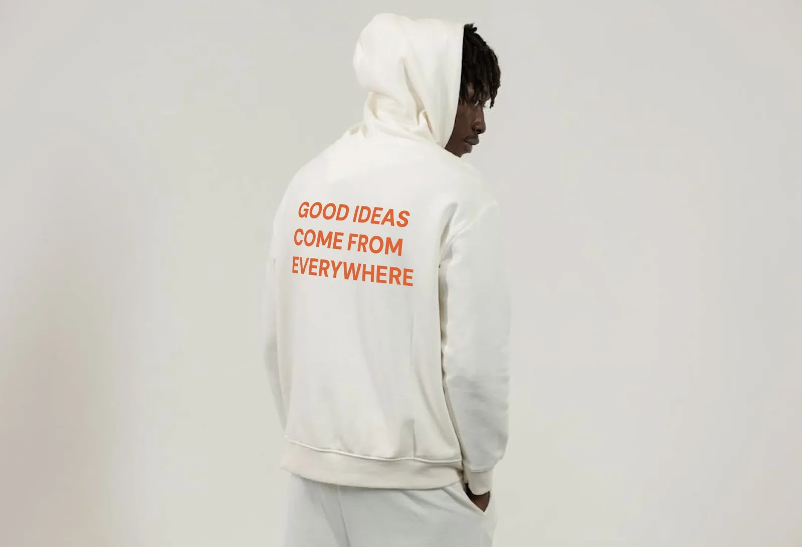 A person in a cream hoodie printed with “Good ideas come from everywhere” — Four Friends Foundation brand work